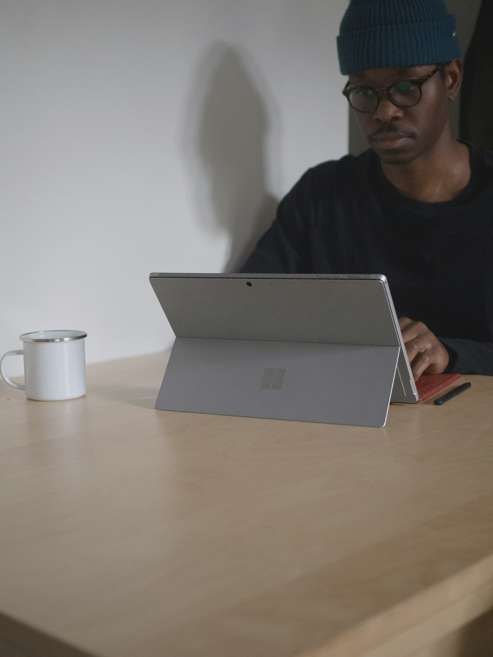 A man reviewing work on a tablet computer at a desk.